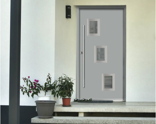 Ușă de intrare modernă gri cu trei ferestre mici pătrate și un mâner lung din oțel inoxidabil într-o fațadă luminoasă cu plante în ghivece.