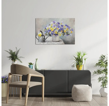Tablou pe pânză cu motiv floral într-o vază și o stropitoare, suspendat deasupra unei comode într-o cameră luminoasă, mobilată modern.