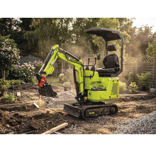 Miniexcavator Zipper pe șenile în timpul lucrărilor de grădinărit pe un șantier cu pământ, pietriș și plante în fundal.