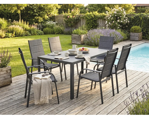 Set modern de mobilier pentru grădină cu masă dreptunghiulară și șase scaune pe o terasă din lemn lângă o piscină.
