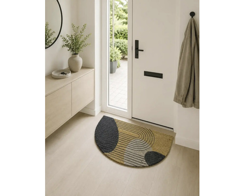 Hol de intrare modern și luminos, cu un covoraș semidisc din fibre de cocos cu model geometric în fața unei uși albe.