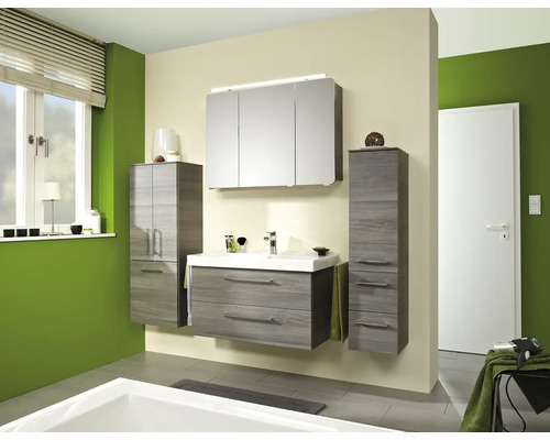 Set modern de mobilier de baie cu aspect de lemn, format din mască de chiuvetă, dulap cu oglindă și iluminare și două dulapuri înalte.