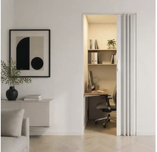 Cameră minimalistă cu o ușă pliantă care duce la un spațiu de lucru compact și organizat, cu birou și rafturi.