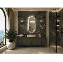 Baie modernă cu perete din marmură verde, oglindă ovală iluminată, lavoar pe blat alb pe mobilier și cabină de duș de tip walk-in.