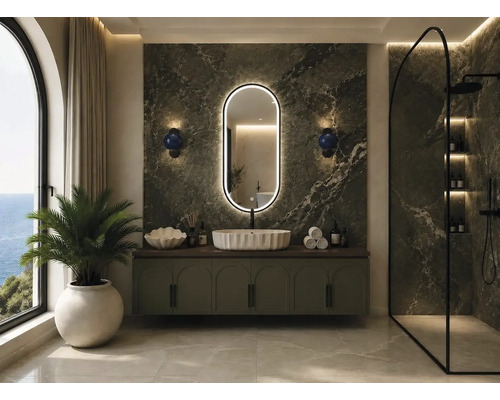 Baie modernă cu perete din marmură verde, oglindă ovală iluminată, lavoar pe blat alb pe mobilier și cabină de duș de tip walk-in.