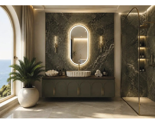 Baie de lux cu perete din marmură verde închis, oglindă LED ovală, dulap de lavoar verde, lavoar pe blat alb și duș de tip walk-in.