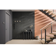 Hol modern cu perete închis la culoare cu aspect de marmură, perete de culoarea piersicii, scară din lemn cu balustradă metalică și consolă neagră.