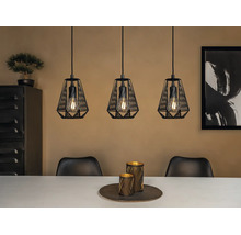 Pendul cu trei brațe cu abajururi din sârmă metalică neagră și becuri vizibile deasupra unei mese de dining într-un interior modern.