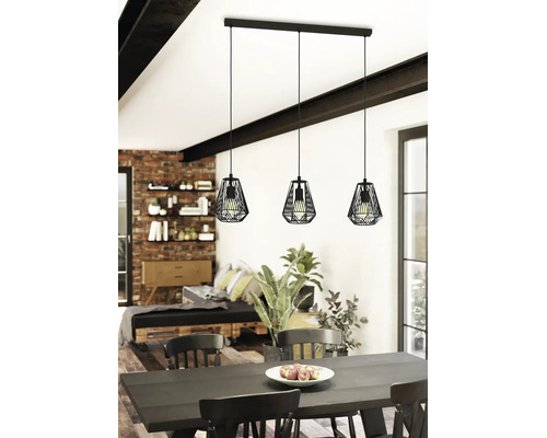 Lustră suspendată cu trei brațe, design industrial, cu abajururi din cușcă metalică neagră deasupra unei mese într-o cameră modernă.