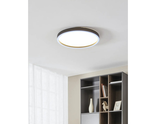 Plafonieră LED rotundă modernă într-un interior luminos și organizat, cu raft și perdea.