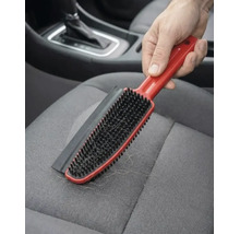 Perie pentru îndepărtarea părului de animale cu margine de cauciuc pe un scaun auto din material textil.