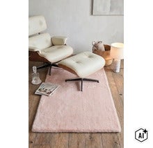Fotoliu lounge cu taburet din piele și lemn pe un covor pufos într-un living modern. (Image AI modified or generated)