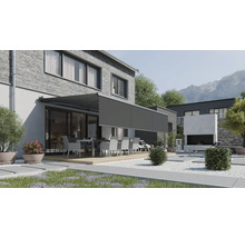 Marchiză de terasă modernă cu volan retractabil montată pe o casă cu fațadă din cărămidă și grădină cu set de mobilier.