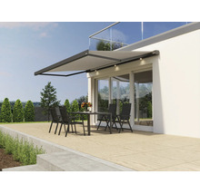 Copertină retractabilă modernă cu iluminare LED integrată montată pe fațada unei case deasupra unei terase cu mobilier de grădină