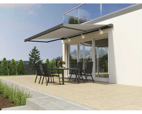 Copertină retractabilă modernă cu iluminare LED integrată montată pe fațada unei case deasupra unei terase cu mobilier de grădină
