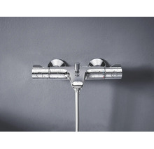 Baterie termostatată de duș montată pe perete din metal cu picături de apă pe suprafață