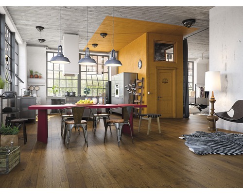Living luminos cu podea din lemn, masă, scaune și bucătărie în stil loft