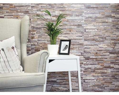Tapet d-c-fix Ceramics Stone wall sand 67,5x400 cm Perete decorativ din piatră cu fotoliu, masă și plantă de interior pentru o ambianță primitoare.