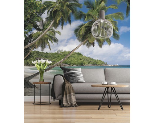 Cameră de zi cu fototapet care prezintă o plajă tropicală cu palmieri și un cer albastru