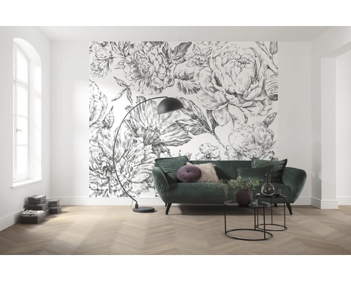 Living cu tapet cu model floral, canapea verde și lampadar