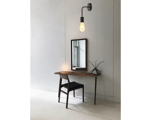 Interior cu un birou, o oglindă și o lampă de perete.