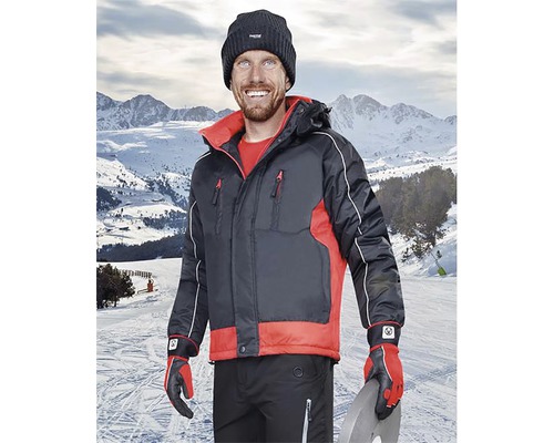 Bărbat cu geacă de iarnă, căciulă și mănuși în fața unui peisaj montan înzăpezit