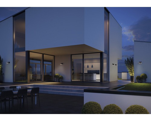 Fațadă modernă de casă cu iluminat exterior și zonă de grădină în amurg