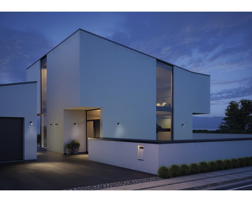 Casă modernă cu iluminat exterior și ferestre mari la amurg