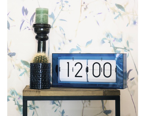 Scenă decorativă cu ceas cu clapetă, lumânare și cactus pe un raft