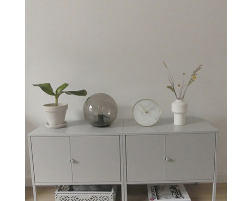 Bufet cu plantă de apartament, lampă de masă, ceas și vază