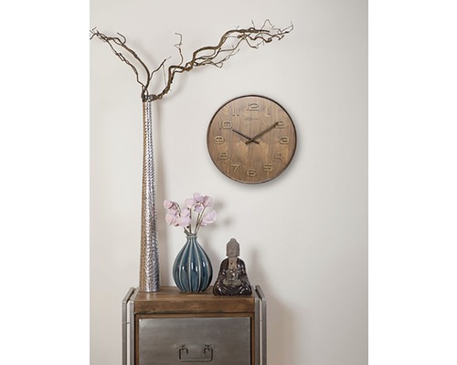 Decorarea camerei de zi cu un ceas, vaze și o figurină Buddha pe o măsuță laterală