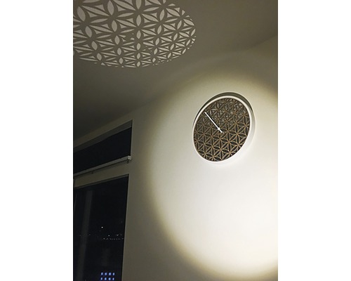 Ceas decorativ de perete cu model geometric şi efect de lumină pe tavan