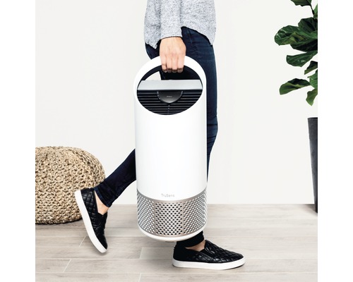 Persoană care poartă un purificator de aer TruSens alb cu mâner