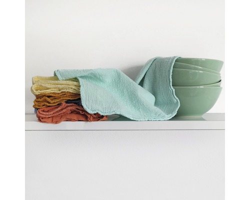 Stivă de cârpe de spălat din material textil și boluri pe un raft