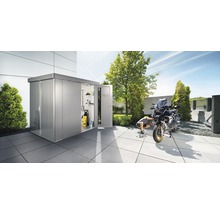 Magazie metalică pentru unelte cu ușa deschisă, motocicletă și persoană în grădină.