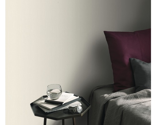 Tapetă deschisă la culoare în dormitor cu noptieră și pat