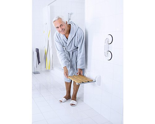 Baie cu bărbat în halat, scaun de duș și bară de sprijin