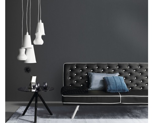 Living cu canapea neagră, măsuță laterală și lămpi suspendate