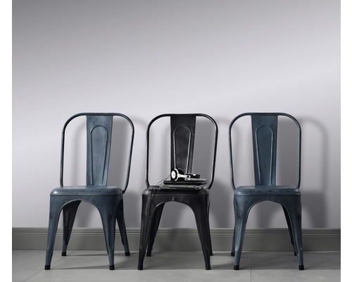 Trei scaune metalice cu design industrial, scaunul din mijloc cu căști și blocnotes