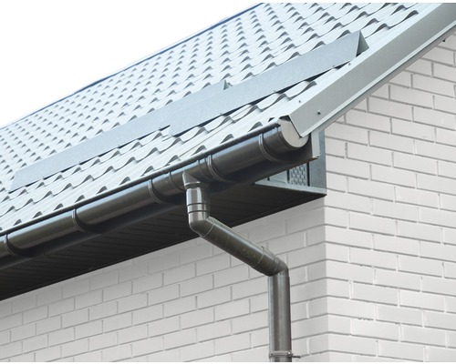 Jgheab și burlan la o casă cu acoperiș din țiglă și fațadă din cărămidă albă.