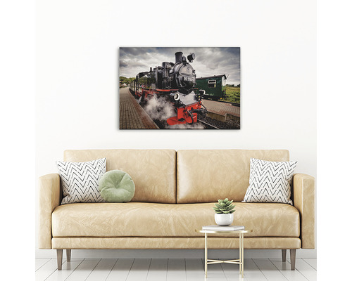 Tablou cu o locomotivă neagră cu aburi în gară