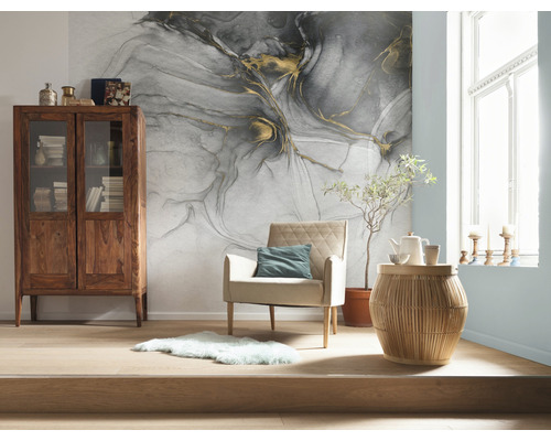 Cameră de zi cu tapet cu model, dulap din lemn, fotoliu și măsuță laterală