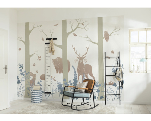 Cameră pentru copii cu motive de animale sălbatice pe perete, un raft negru, un balansoar și o bară de măsurare.