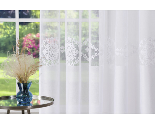 Șaluri decorative cu model în fața unei ferestre