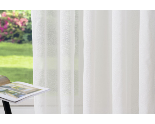 Cortină panel albă, transparentă, în fața unei ferestre