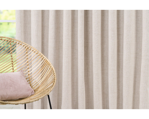 Perdea decorativă lângă un scaun de ratan cu pernă