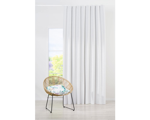 Perdea albă lângă un scaun de ratan într-o cameră luminoasă.
