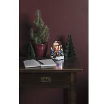 Aranjament decorativ cu birou, caiet, stilou, pomi de Crăciun și scenă de Crăciun iluminată