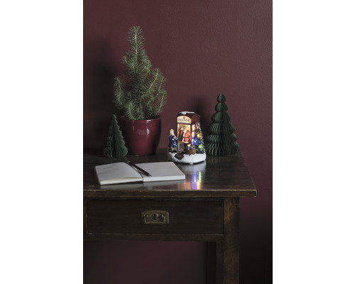 Aranjament decorativ cu birou, caiet, stilou, pomi de Crăciun și scenă de Crăciun iluminată