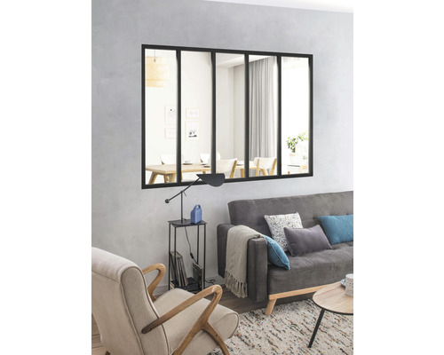 Cameră de zi cu fereastră neagră cu grilaj, folosită ca decorațiune de perete deasupra unei canapele gri